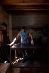 Focused man standing at workbench in dark garage