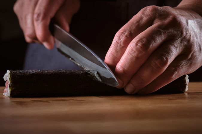 Male shushi man hands preparing different pieces of makis