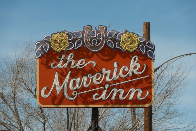 Daytime view of a neon sign for the Maverick Inn in Alpine, Texas