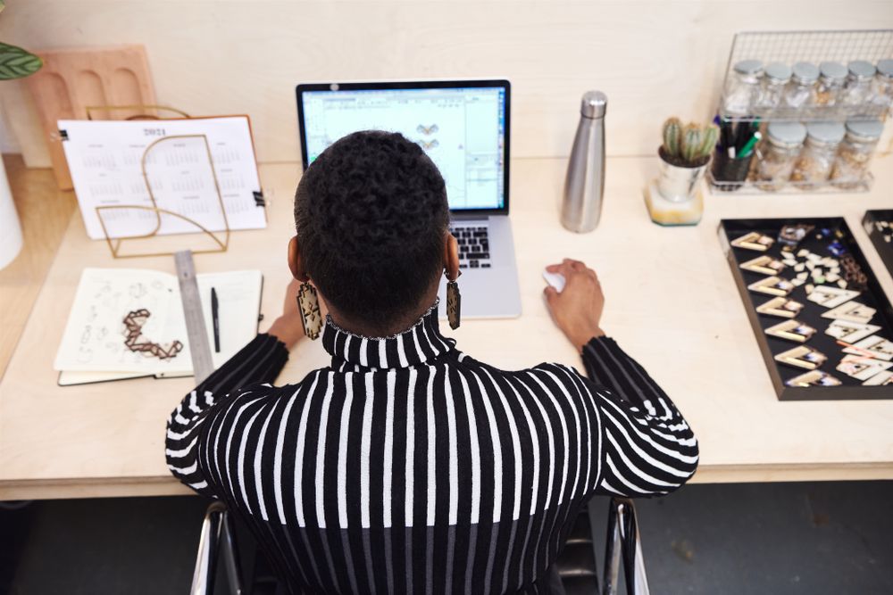 Woman working on jewelry design on a laptop