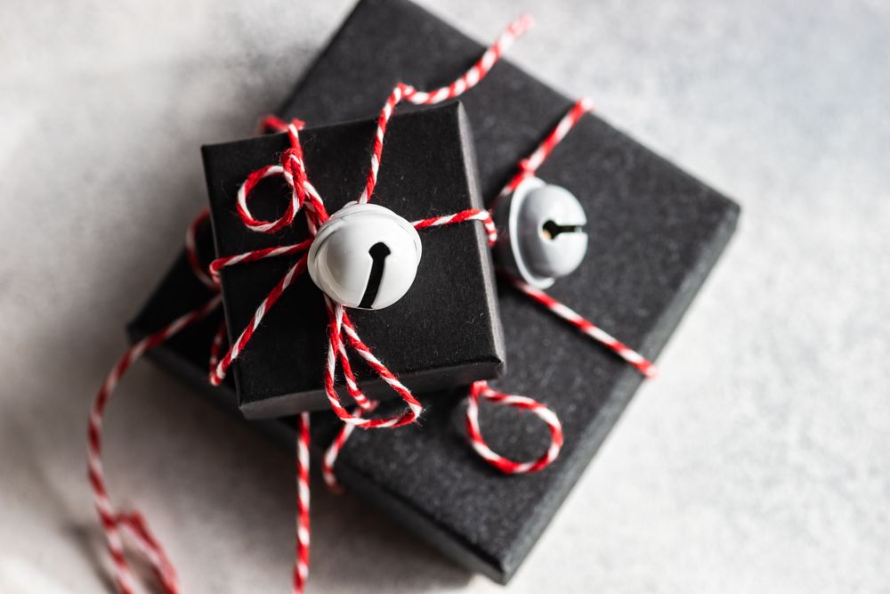 Holiday gift boxes with decorative bells on stone background with copy space
