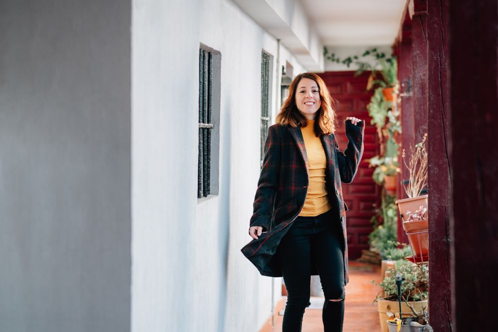 Smiling woman going on corridor in house