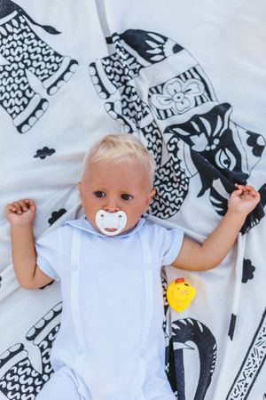 Top view of a blonde baby with pacifier