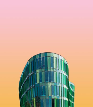 Green building against a gradient pink and orange sky