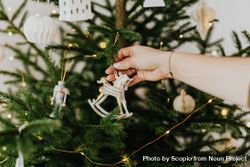 Person holding silver Christmas ornament 5rKdn4