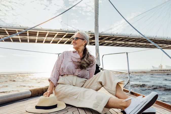 Stylish mature woman enjoying the view from a yacht bow