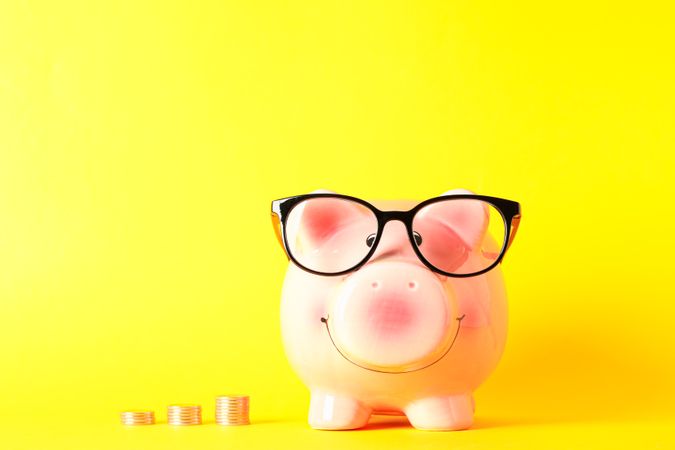 Happy piggy bank with dollars on color background, space for text. Finance, saving money