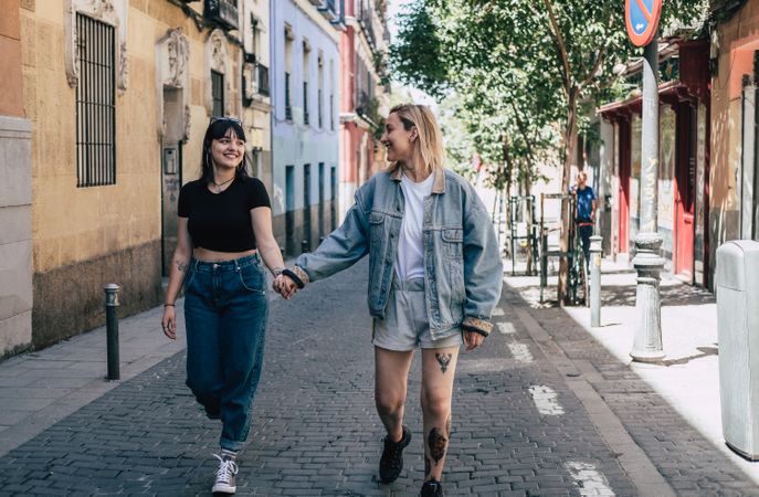 Lesbian couple holding hands walking on street