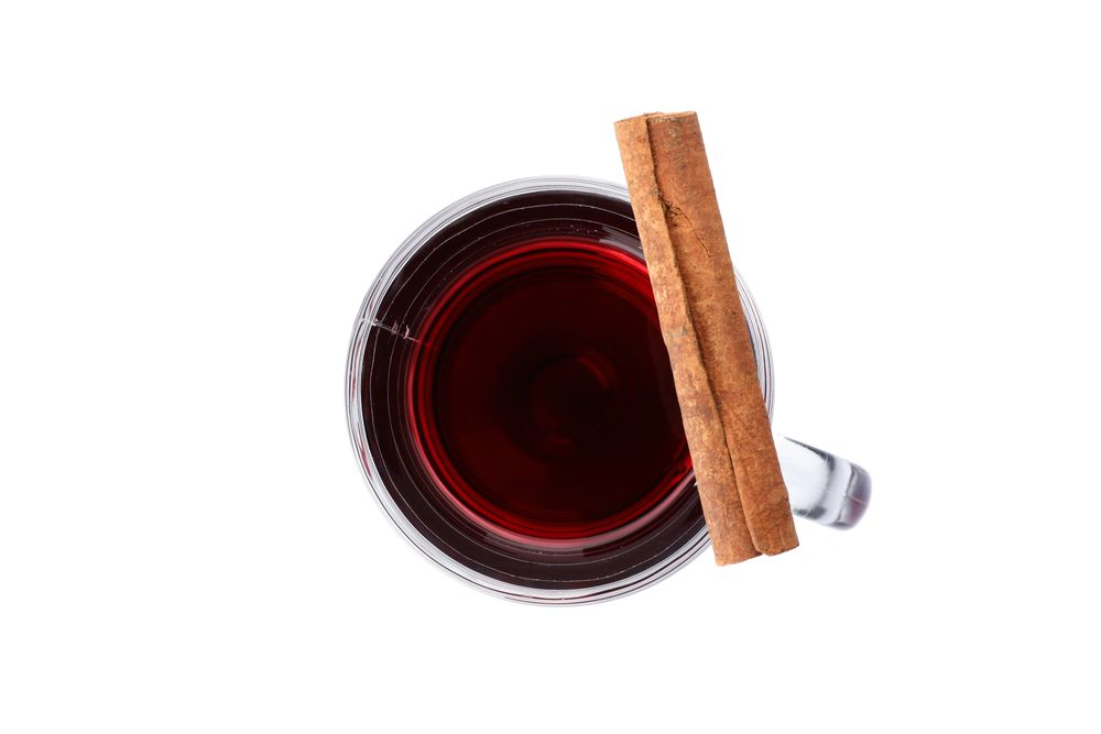 Glass of tasty mulled wine isolated on studio background, top view