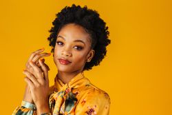 Elegant Black woman holding her hands to her face