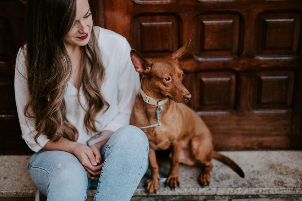 Woman with purebred dog on stone porch