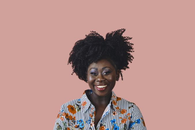 Studio shot of happy Black woman in floral print shirt