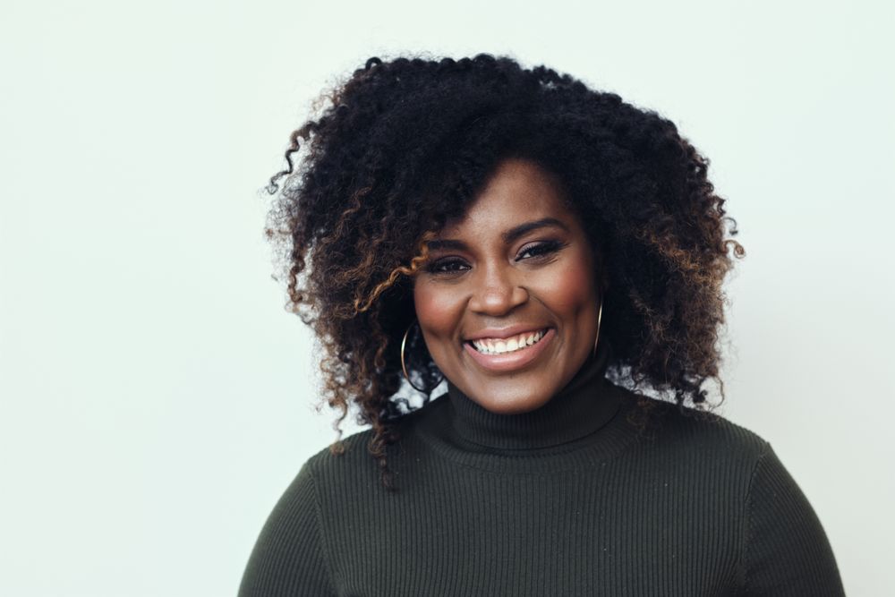 Portrait of a Black woman smiling in studio shoot