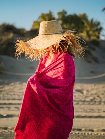 Woman with pink pareo on sandy beach