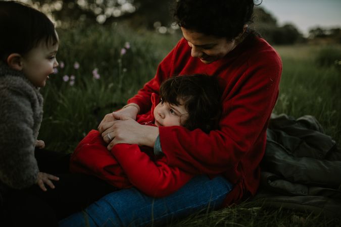 Mother with her young daughter and son in a park