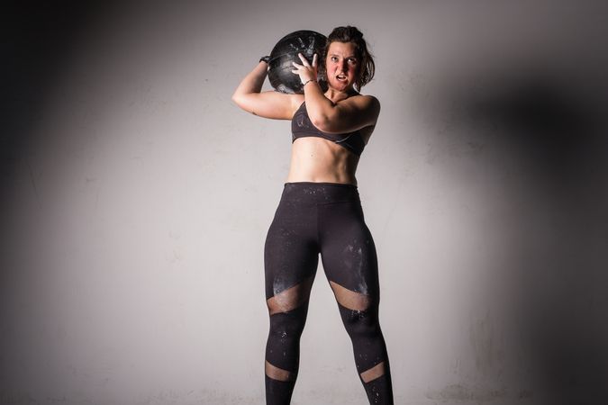 Woman lifting medicine ball in gym