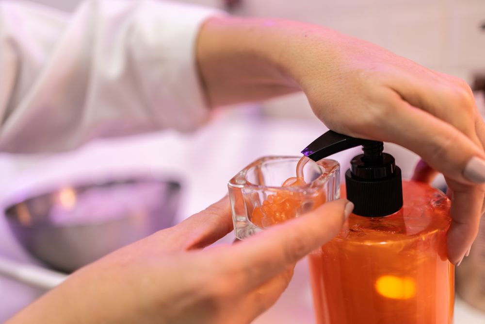 Female hands pumping cream into glass