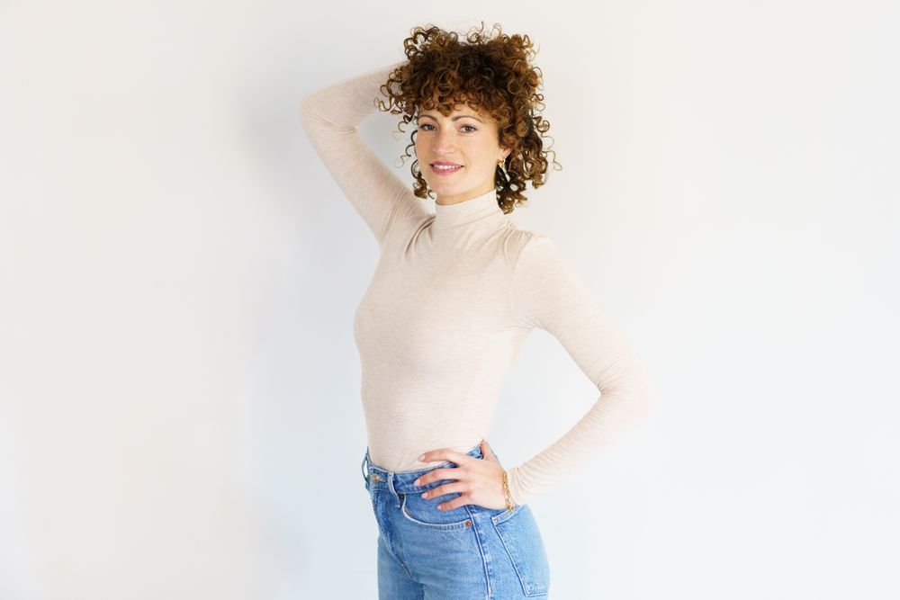Confident woman in casual clothes with one hand through hair