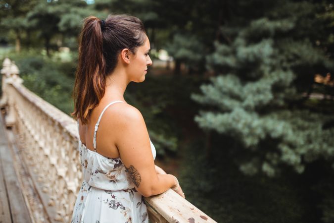 stylish woman sitting on stairs of park in New York smelling flowers