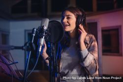 Woman singing a song in music recording studio 5lmnv4