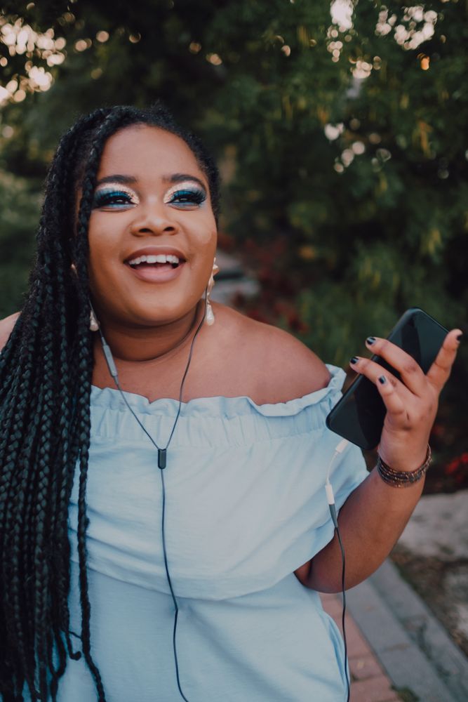 Happy trendy Black woman listening music