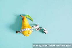 Yellow pear with measuring tape on blue background 5wVOm0