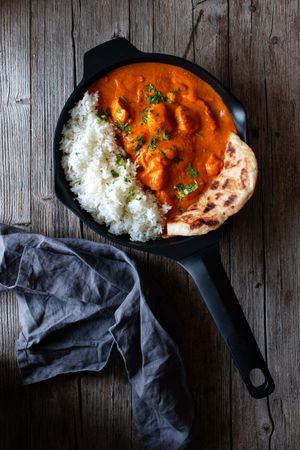 Close up of skillet full of delicious butter chicken and rice