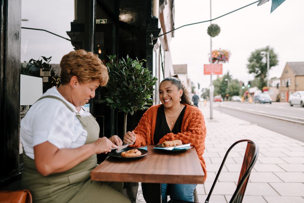 Mother and daughter enjoying sandwiches at outdoor cafe table