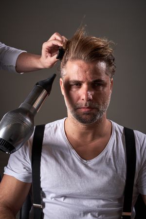 Handsome confident brutal man in barbershop