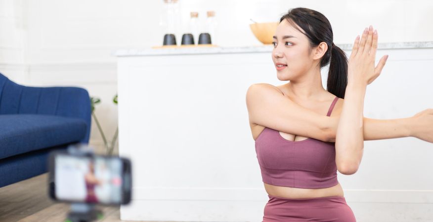 Asian sporty woman in sportswear live streaming online for teaching yoga