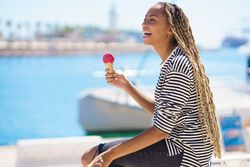 Female enjoying ice cream cone on the waterfront