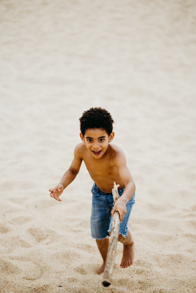 Black boy playing on beach