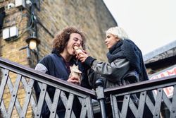 Couple sharing sandwich outside
