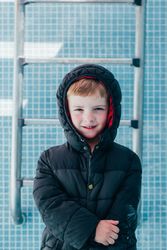 Boy in warm clothes standing in empty pool
