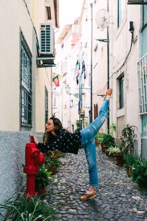 Casual woman dancing on old city street