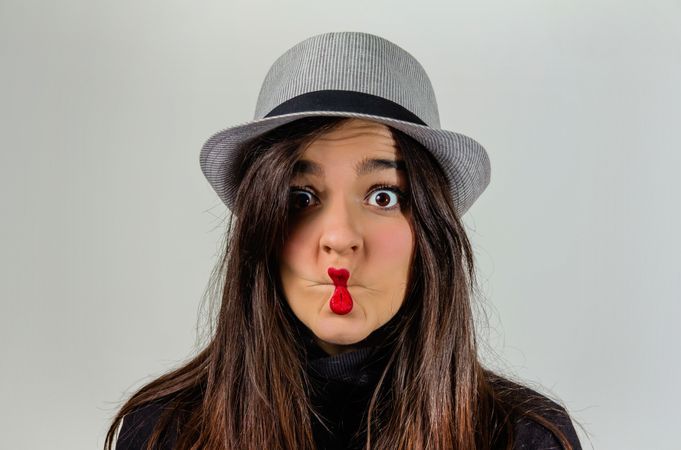Woman gesturing with her red lips over gray background