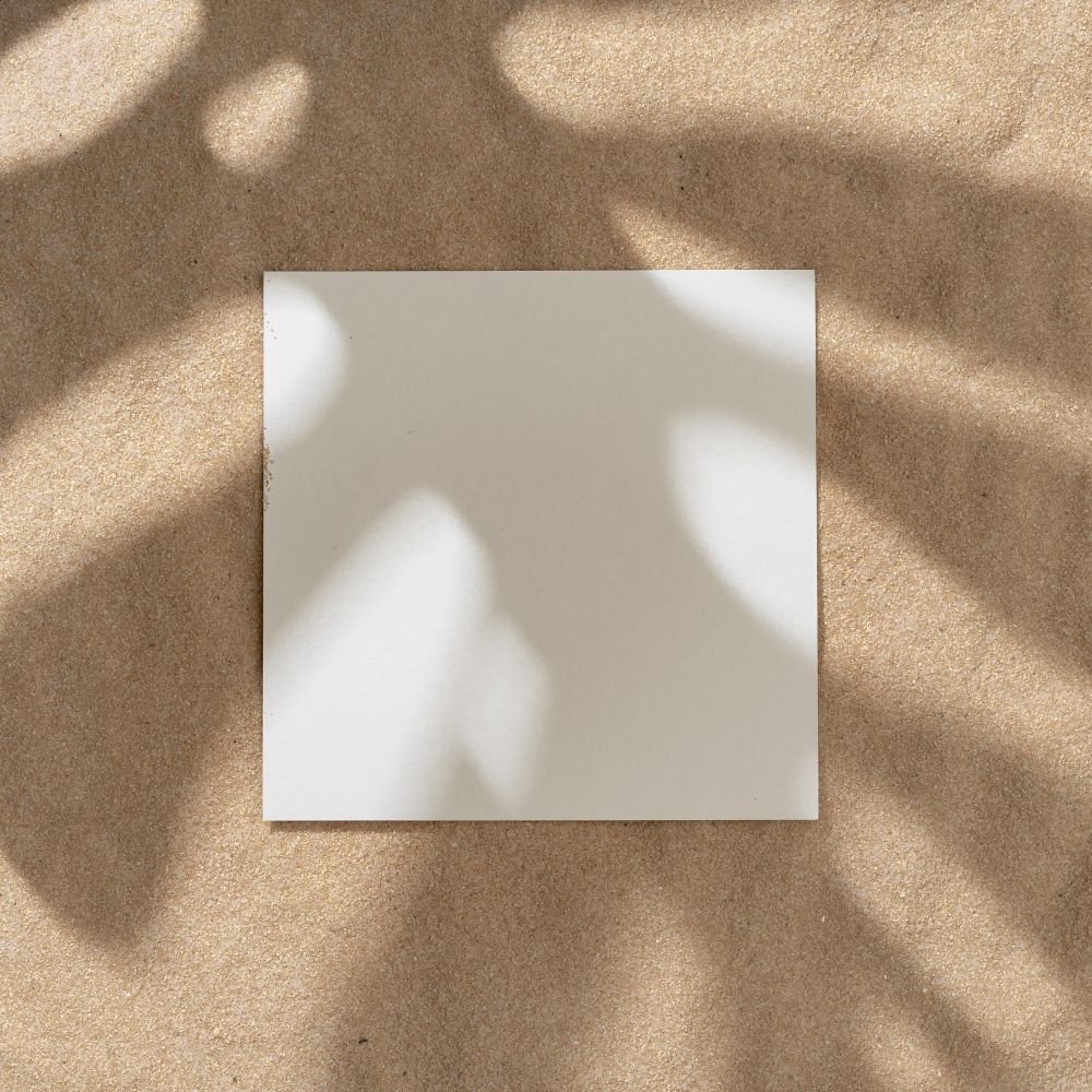 Sand with palm leaf shadows and central square