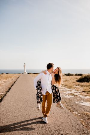 Happy lovers having fun on path from sea