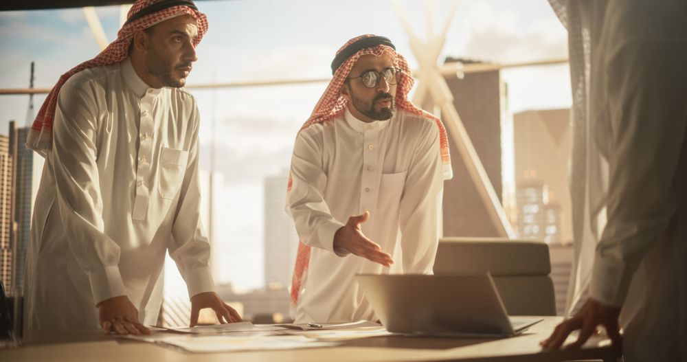 Successful Muslim Businessmen in Traditional Outfits Having an Office Meeting, Negotiating and Talking About Financial Opportunities.