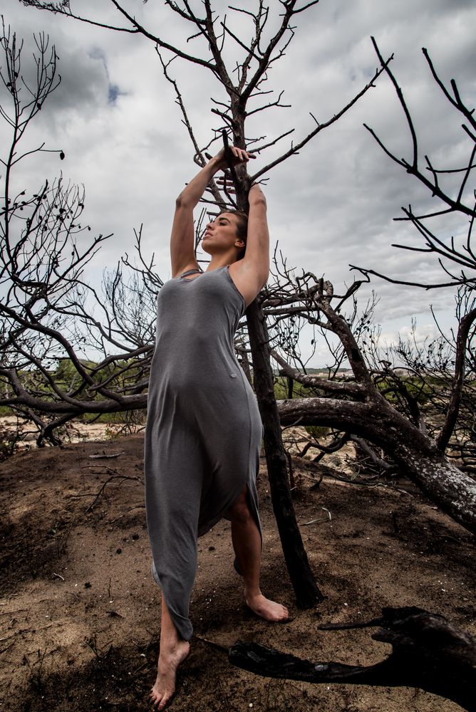 Woman posing on twigs of dry trees