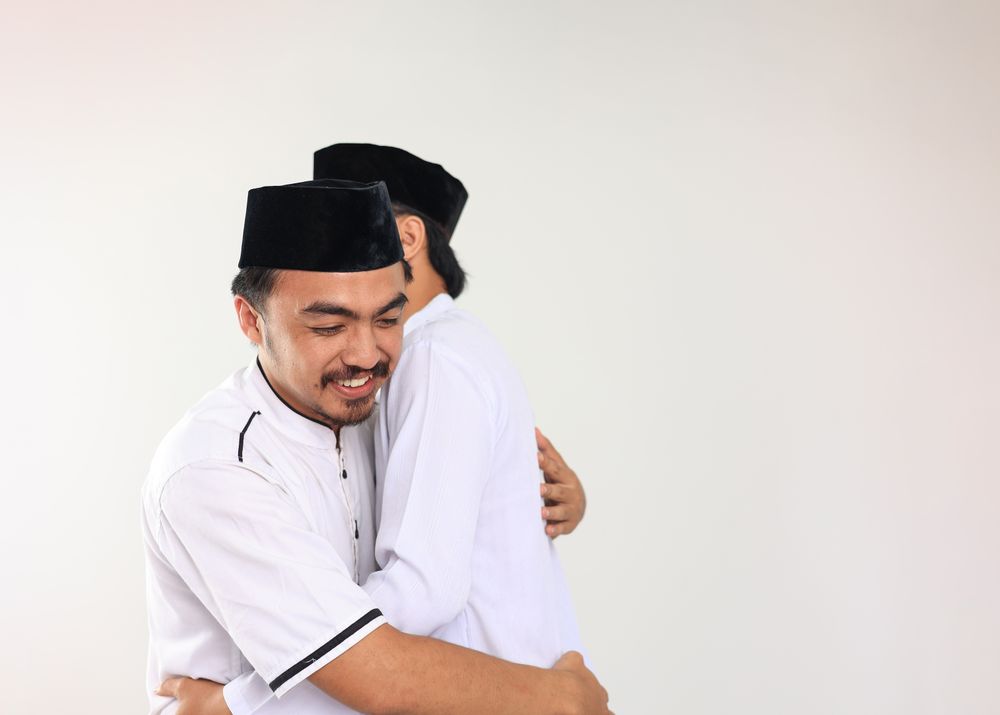 Two Young Indonesian  Muslim Male Hug and Smiling during Eid Al Fitr Festive
