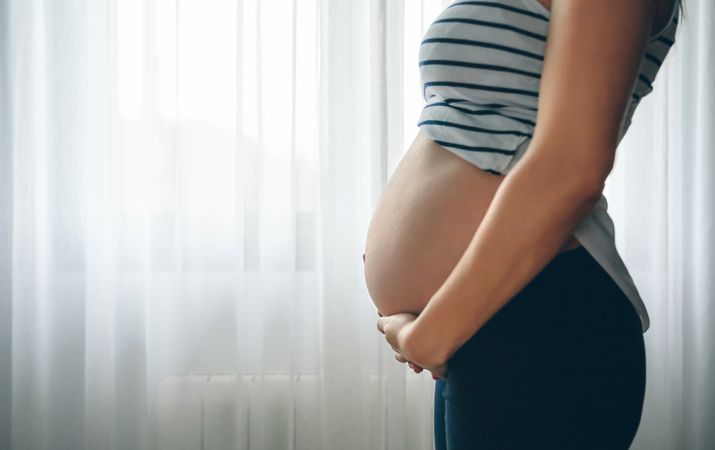 Pregnant woman holding her tummy