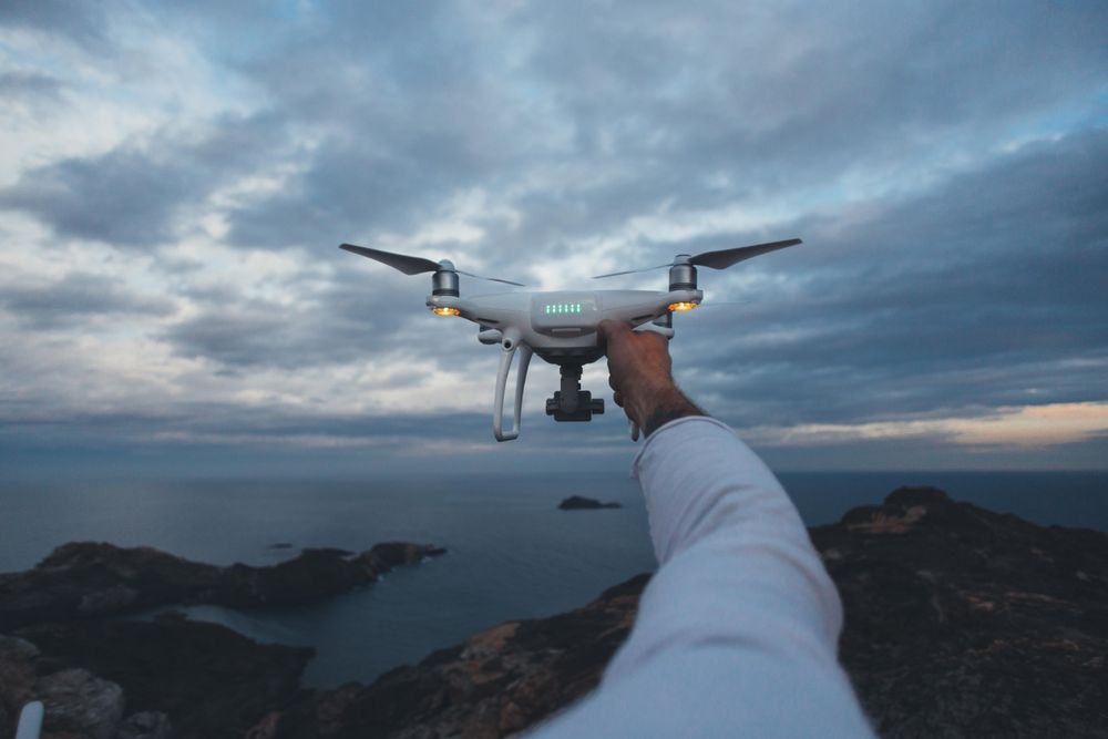 Arm holding up drone on overcast day
