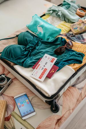 Open woman suitcase prepared for summer vacation