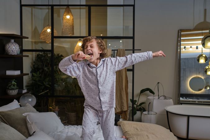 Carefree boy singing in bedroom