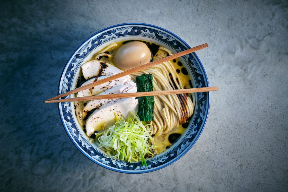 Delicious ramen with chicken fillet slices and chopsticks