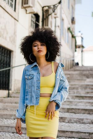 Stylish female standing on stairs with railing outdoors