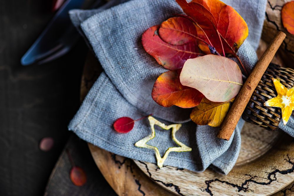 Fall table setting with yellow and red leaves on rustic background with copy space