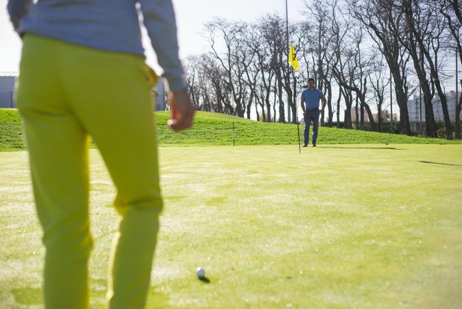 Two men standing away from each other at golf court