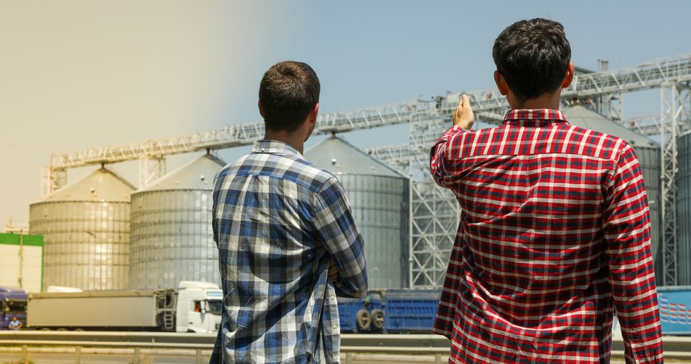 Two farmers against grain silos. Agriculture business
